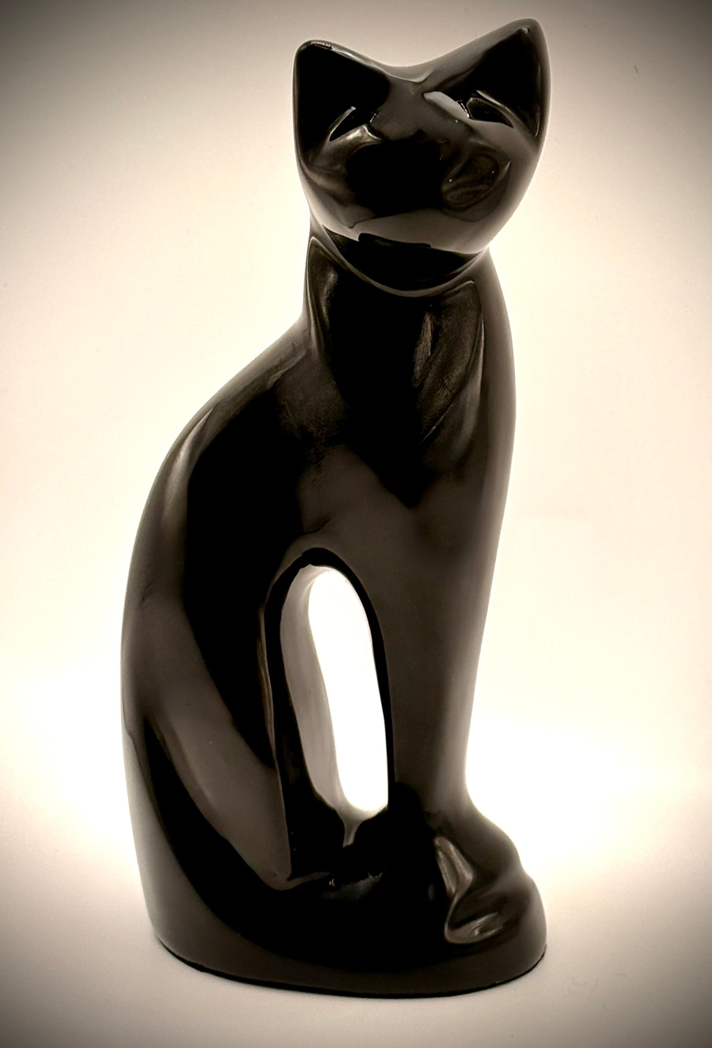 Black cat-shaped  figurine on a beige background