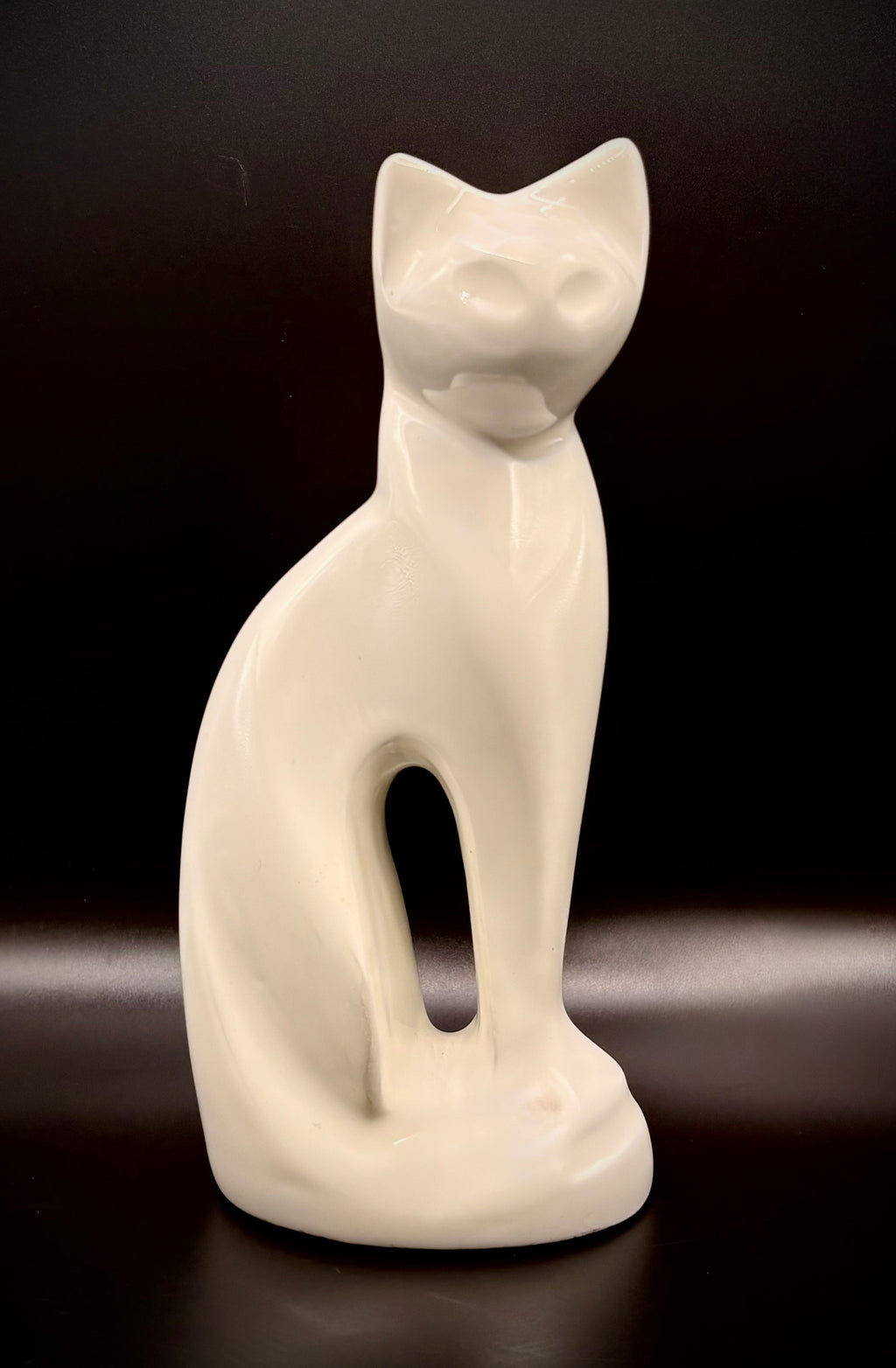 White cat figurine on a dark background