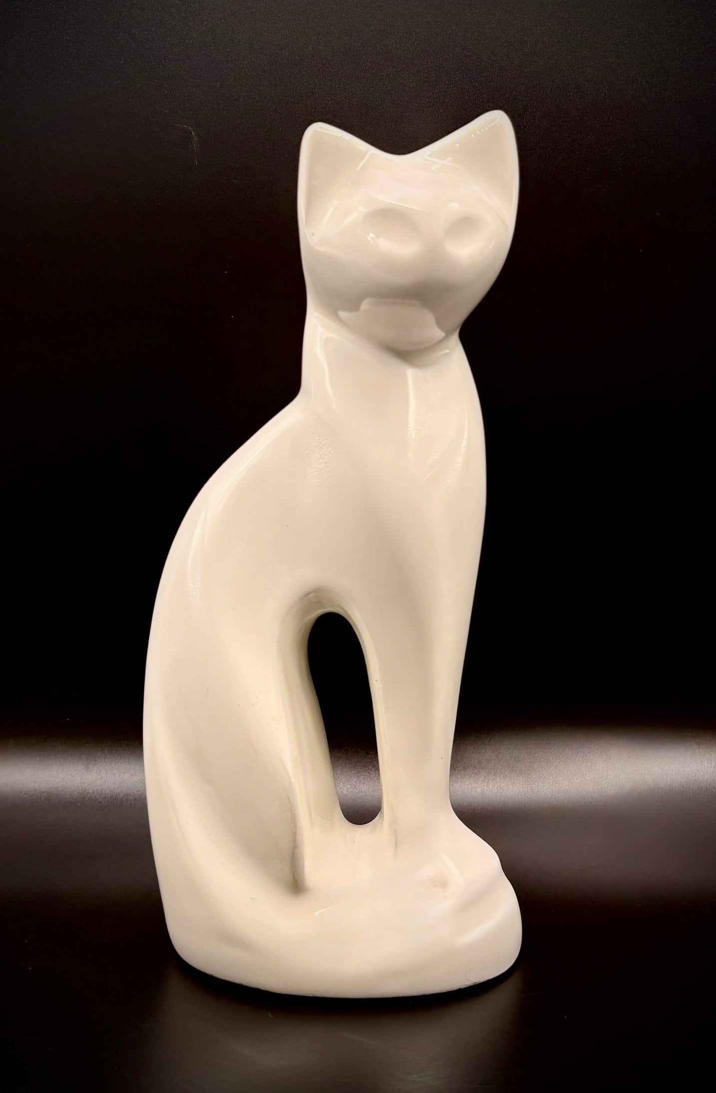 White cat figurine on a dark background